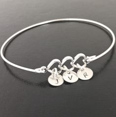 "Family Triple Heart Bracelet - Personalized Mother's Day Gift Jewelry A silver tone charm of 3 hearts will be transformed into a personalized family bracelet with the initials of family members on sterling silver discs, and bangle band choice of silver filled or sterling silver. Personalize with the initials of 3 children or 3 grandchildren for your three hearts bracelet. I can also fit \"Mom\" on a larger disc charm which would go in the middle of 2 kids initials. Also makes a nice bracelet fo Adjustable Double Heart Sterling Silver Charm Bracelet, Adjustable Sterling Silver Double Heart Charm Bracelet, Adjustable Double Heart Charm Bracelet For Anniversary, Adjustable Heart Charm Bracelet For Anniversary, Adjustable Silver Double Heart Charm Bracelet, Silver Adjustable Double Heart Charm Bracelet, Silver Heart Charm Bracelet For Birthday, Adjustable Charms Heart Bracelet For Anniversary, Family Bracelet