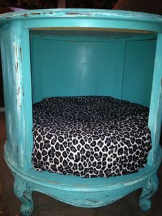 an upcycled bed with a leopard print cover on it and a blue frame