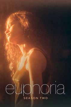 a woman with long hair standing in front of a dark background and the words euphora on it