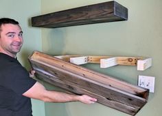 a man is holding a wooden box in front of two shelves with tags on them