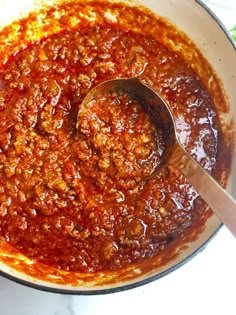 a pot filled with chili sauce and a spoon in it