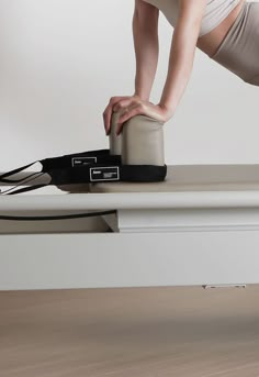 a woman is bending over with her leg on the edge of a table while stretching