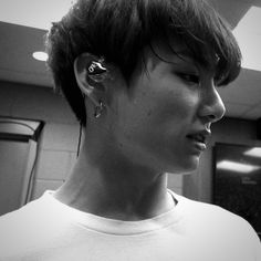 a young man with ear piercings on his ears looking off to the side in an elevator