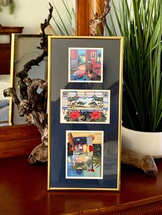 a wooden table topped with pictures and a potted plant