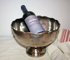 two bottles of wine in a silver bowl