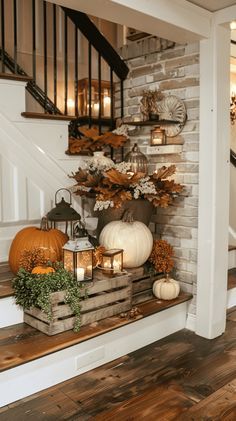 an entry way decorated for fall with pumpkins and gourds on the stairs