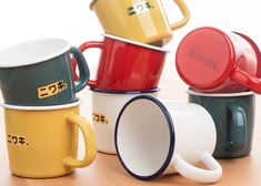 four different colored coffee mugs stacked on top of each other