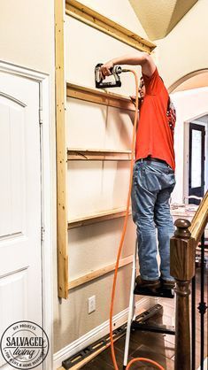 a man in an orange shirt is painting the walls