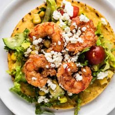 shrimp and avocado salad with feta cheese on tortilla shell in white plate