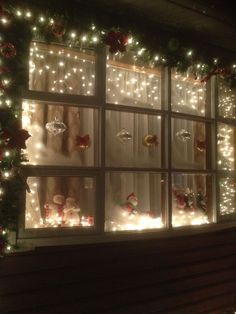 a window with christmas decorations and lights in it