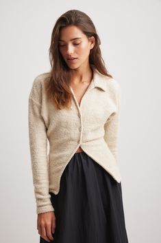 This sweater features a structured, slightly stretchy material and a form fit. It has a classic collar and a v neckline. Our sweater features button closures down the front. Classic Cream V-neck Long Sleeve Sweater, Fitted Knit V-neck Polo Sweater, Fitted V-neck Knit Polo Sweater, Fitted V-neck Sweater With Seamless Collar, White V-neck Polo Sweater For Fall, Fitted Cream Polo Sweater For Fall, Cream Fitted Button-up Sweater, Fitted Cream Button-up Sweater, Elegant V-neck Knit Polo Sweater