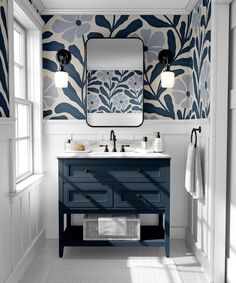 a bathroom with blue and white wallpaper on the walls, two sinks and a mirror