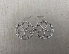 "These are so unique and cool! Big silver flower hoop earrings. They are modern and whimsical. Eye catching and versatile. Dress them up or down. The earrings measure 1 3/8\" long by 1 3/8\" wide and are made from plated silver. They hang from simple silver ear wire hooks. Overall drop length is 1 1/2\". I have a matching necklace in my shop if you would like the whole set. Here is a direct link Thanks for stopping by! Please take a moment and visit the rest of my Etsy store. I have many more un Spring Hoop Earrings With Flower Charm As Gift, Spring Flower Charm Hoop Earrings As Gift, Silver Flower Metal Earrings For Spring, Spring Silver Metal Hoop Earrings, Silver Metal Flower Earrings For Spring, Silver Metal Hoop Earrings For Spring, Modern Metal Earrings For Spring, Spring Gift Hoop Earrings With Flower Charm, Whimsical Spring Flower Earrings With Ear Wire