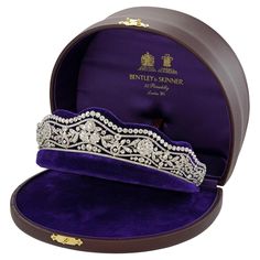 a purple velvet jewelry box with a tiara in it