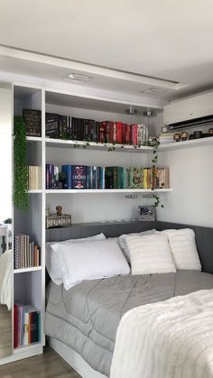 a bed sitting under a book shelf filled with books