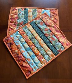 a quilted placemat with many different patterns on it sitting on a wooden table