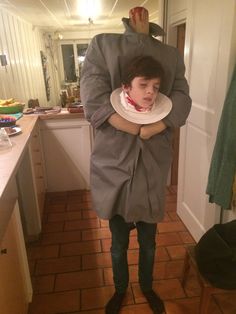 a man is standing in the middle of a kitchen with his head on a woman's shoulders