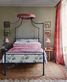 a bedroom with a canopy bed and pink curtains