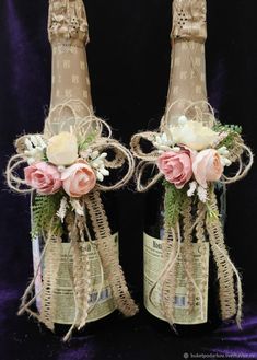 two champagne bottles decorated with flowers and ribbons