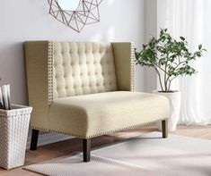 a beige chair sitting on top of a wooden floor next to a potted plant