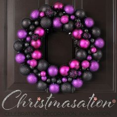 a purple and black christmas ornament wreath on a door with the words christmasaton