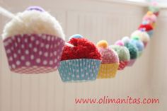 colorful cupcakes are hanging from a string with polka dots and pom - poms