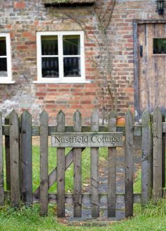 an old brick building with a wooden fence in front of it that says,'natstifield cottage '