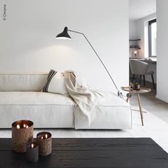 a living room with a white couch and two candles