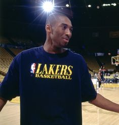 a man standing in front of a basketball court with his hands out to the side