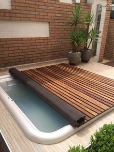 an inflatable hot tub on a deck with potted plants next to it