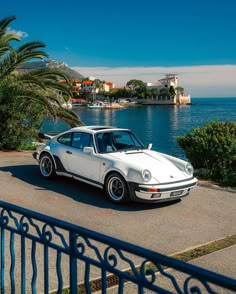 a white car parked next to the ocean