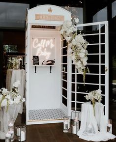 the entrance to a wedding ceremony with white flowers and candles in vases on the floor