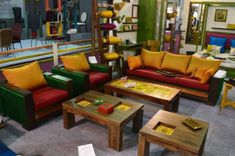 a living room filled with lots of different colored couches and tables in front of a mirror