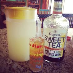 a bottle of sweet tea next to a glass with ice and lemonade in it