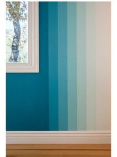 an empty room with blue and green striped walls