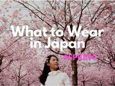 a woman standing in front of a tree with pink flowers and the words what to wear in japan