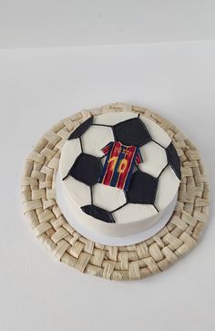 a cake with a soccer themed frosting on it sitting on top of a wicker plate