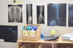 a room with several pictures on the wall and various items in baskets next to it