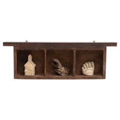 an old wooden shelf with three clay hand and foot figurines on it's sides