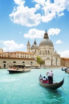 two gondolas on the water in front of buildings