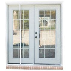 a white double door with glass and brick walkway