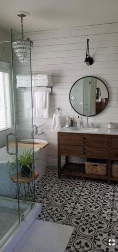 a bathroom with black and white tile flooring next to a walk - in shower