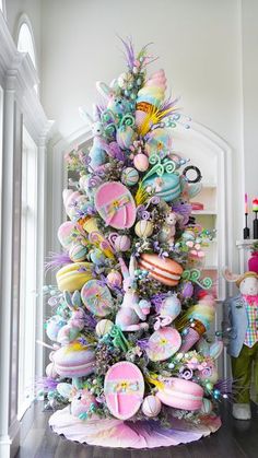 a decorated christmas tree in the corner of a room with lots of ornaments on it