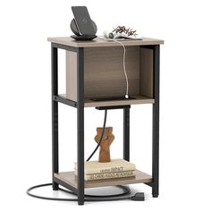 a book shelf with an electronic device on top of it and a charging cord attached to the side