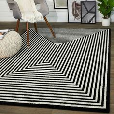 a black and white area rug in a room with pictures on the wall behind it