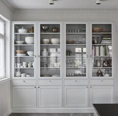 a large kitchen with white cabinets and black counter tops in front of a stove top oven