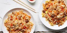 two white plates filled with food next to chopsticks