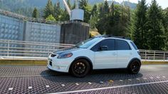 a small white car parked on top of a parking lot