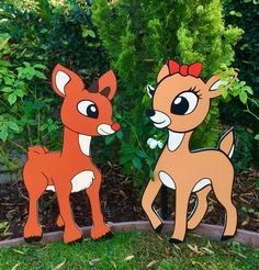 two wooden deer standing next to each other