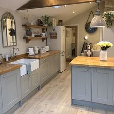 a large kitchen with wooden floors and gray cupboards on the walls, along with an island